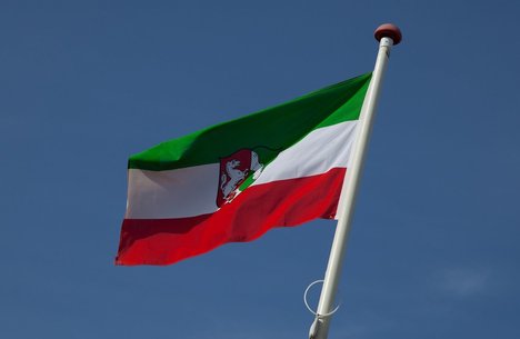 Das Foto zeigt eine wehende Fahne des Landes NRW