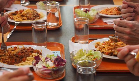 Foto zur Pressemitteilung der Linken NRW zu Vorfällen in Tönnies Kantine zeigt Menschen beim Essen in einer Kantine.  